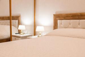 a bedroom with a large white bed and two lamps at Caesarea Vacation Rooms in Caesarea