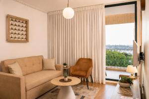a living room with a couch and a chair and a window at Caesarea Vacation Rooms in Caesarea +58 photos