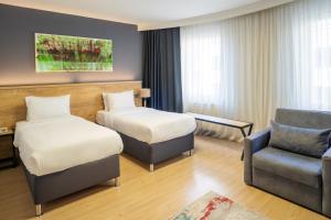 a hotel room with two beds and a chair at Adresin Hotel in Edirne +45 photos