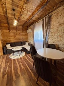 a living room with two tables and a couch at Ðedovina mountain cabins in Žabljak