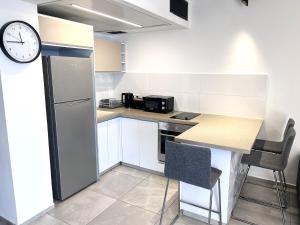 a kitchen with a counter and a clock on the wall at Apartments4you Leonardo 17 in Bat Yam