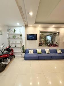 a living room with a blue couch and a motorcycle at Hoang Vu Guest House in Da Lat