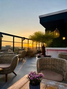 a patio with chairs and a table with a sunset in the background at Twins Hotel in Duisburg