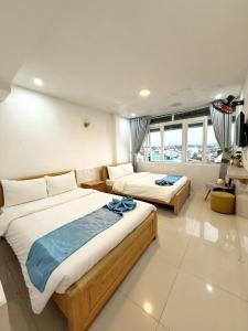 a bedroom with two beds and a living room at Hoang Vu Guest House in Da Lat