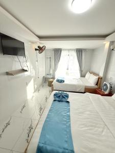 a bedroom with two beds with a blue bow on it at Hoang Vu Guest House in Da Lat +27 photos