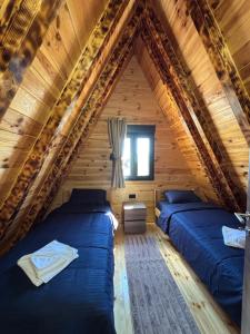 two beds in a room in a log cabin at Ðedovina mountain cabins in Žabljak