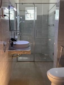 a bathroom with a glass shower and a sink at Judewin villa Negombo in Negombo +45 photos
