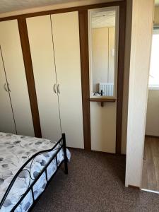 a bedroom with a bed and a mirror at California cliffs caravan in Great Yarmouth