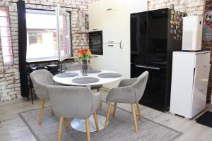 a kitchen with a table and chairs and a refrigerator at Kuća za odmor Leon in Vinkovci