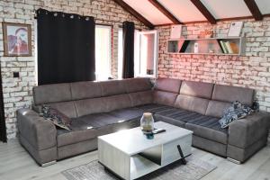 a living room with a leather couch and a table at Kuća za odmor Leon in Vinkovci