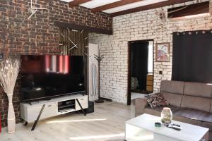 a living room with a large television in a brick wall at Kuća za odmor Leon in Vinkovci +135 photos