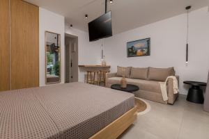 a bedroom with a bed and a couch at Dionisos Resort in Pefkochori