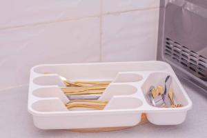 a white plastic container with utensils in it at Mada's House F H L in Abomey-Calavi