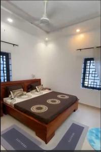 a bedroom with a bed in a room with windows at Mada's House F H L in Abomey-Calavi