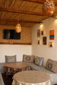 a living room with a couch and a table at Waveside surf house in Tamraght Ou Fella