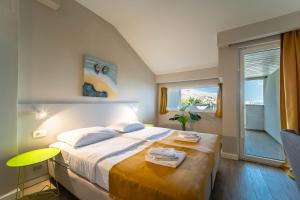 a bedroom with a bed with two towels on it at Hotel Plaza in Pag