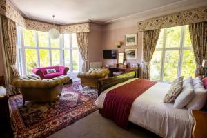 a bedroom with a bed and chairs and windows at Badger Bar in Ambleside