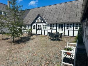ein weiß-schwarzes Gebäude mit einem Tisch und Stühlen in der Unterkunft Tøndegården 3 rooms apartment in Odense
