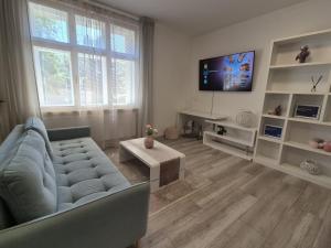 a living room with a blue couch and a tv at Apartman Centrum Mudronova in Košice