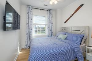 a bedroom with a bed with a blue comforter and a window at Bethany Beach Retreat with Pool - VTC in Frankford