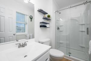 a white bathroom with a toilet and a shower at Bethany Beach Retreat with Pool - VTC in Frankford