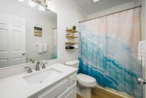 a bathroom with a sink and a toilet and a mirror at Bethany Beach Retreat with Pool - VTC in Frankford
