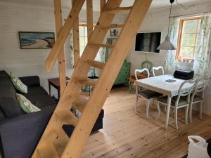 a wooden staircase in a living room with a table at Fårö house in Fårö