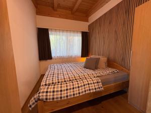 a bedroom with a bed with a checkered blanket at Ferienwohnung Heissl in Fieberbrunn