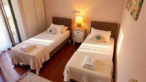 a bedroom with two beds with towels on them at Moustakias Villa in Kefallonia +23 photos
