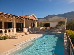 a backyard with a swimming pool and a house at Moustakias Villa in Kefallonia