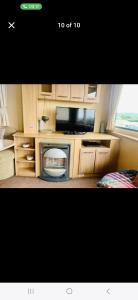 a living room with a tv and a microwave at Caravan 63 Fishguard Holiday Park in Fishguard +7 photos