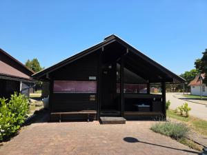 a building with a black roof on a brick sidewalk at Spa Cottage Lavender in Terme Čatež in Čatež ob Savi