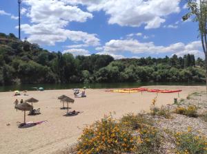a beach with umbrellas and people on the sand at Casa da Talha By Viva a Vida - Alojamentos & Hotels in Constância +11 photos