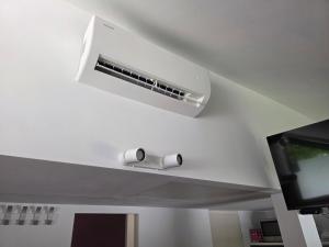 a ceiling mounted air conditioner in a room with a tv at Spa Cottage Lavender in Terme Čatež in Čatež ob Savi