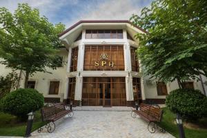 a building with two benches in front of it at Marokand Spa Hotel in Samarkand