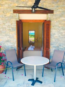 a table and two chairs in front of a bedroom at Aetherion in Agios Ioannis Pelio