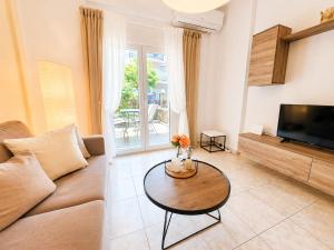 a living room with a couch and a table at Anris & Dianas Dom - In a quiet part of the center in Kallithea Halkidikis