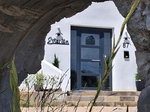 a white building with a blue door at Estación 87 Smart Workation y Relax Mediterráneo in Peniscola