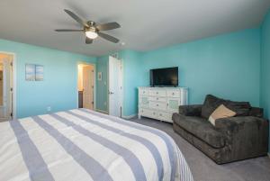 a bedroom with blue walls and a bed and a couch at Villa at Greys Neck - Close to Bethany Beach in Millville