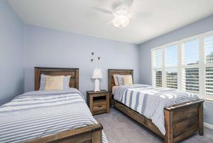 two beds in a bedroom with a ceiling fan at Villa at Greys Neck - Close to Bethany Beach in Millville