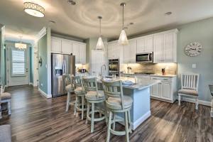 a kitchen with white cabinets and a island with bar stools at Villa at Greys Neck - Close to Bethany Beach in Millville
