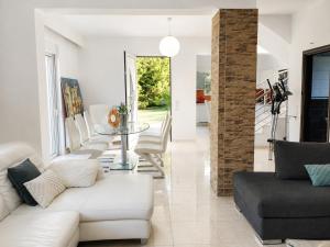 a living room with white furniture and a glass table at Phos & Kipos Villa in Koskinou