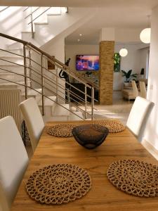 a wooden table with white chairs and a dining room at Phos & Kipos Villa in Koskinou