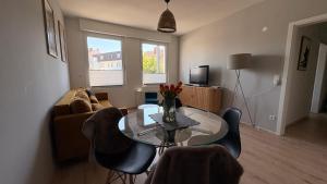 a living room with a table and a couch at BrunnenApart Nova in Bad Oeynhausen