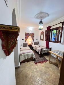 a living room with two beds and a table at Dar Sababa in Chefchaouen