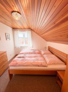 a bedroom with a large bed with a wooden ceiling at Casa Maika in Frymburk