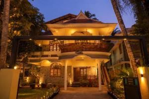 a large house with a lit up facade at night at Lakshmi Ayurveda Retreat in Kovalam