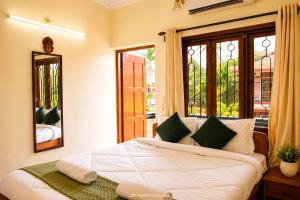 a bedroom with a large white bed with a window at Cliff Heaven in Colva +60 photos