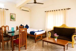 a room with a bed and a table and a couch at Cliff Heaven in Colva