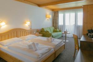 a bedroom with a large bed and a living room at Hotel Metzgerwirt in Sankt Veit im Pongau +57 photos